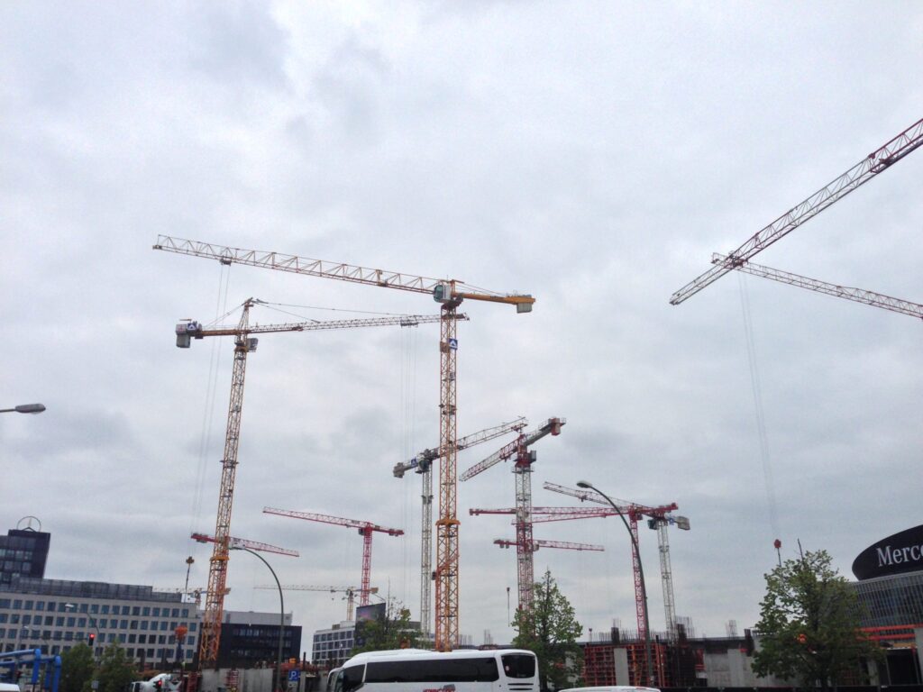 Several construction cranes against the sky
